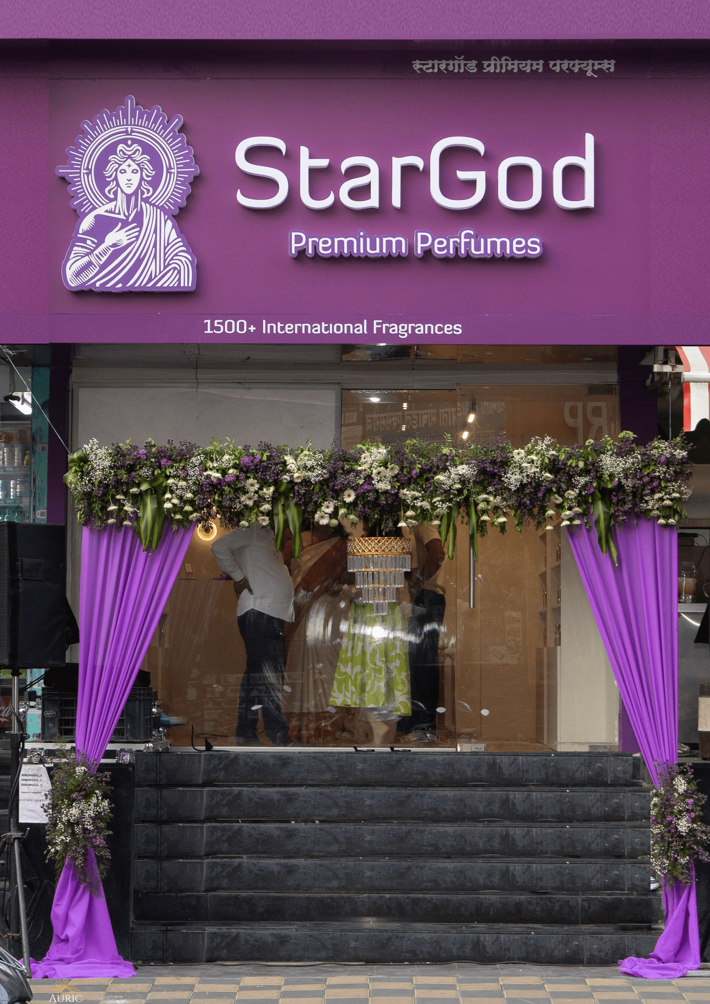 The StarGod boutique storefront on Tilak Road — purple signboard with the haloed wordmark and '1500+ International Fragrances', floral arch and deep purple drape curtains over the entrance.